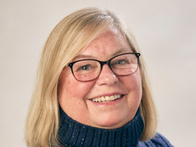 a person wearing glasses and a blue sweater