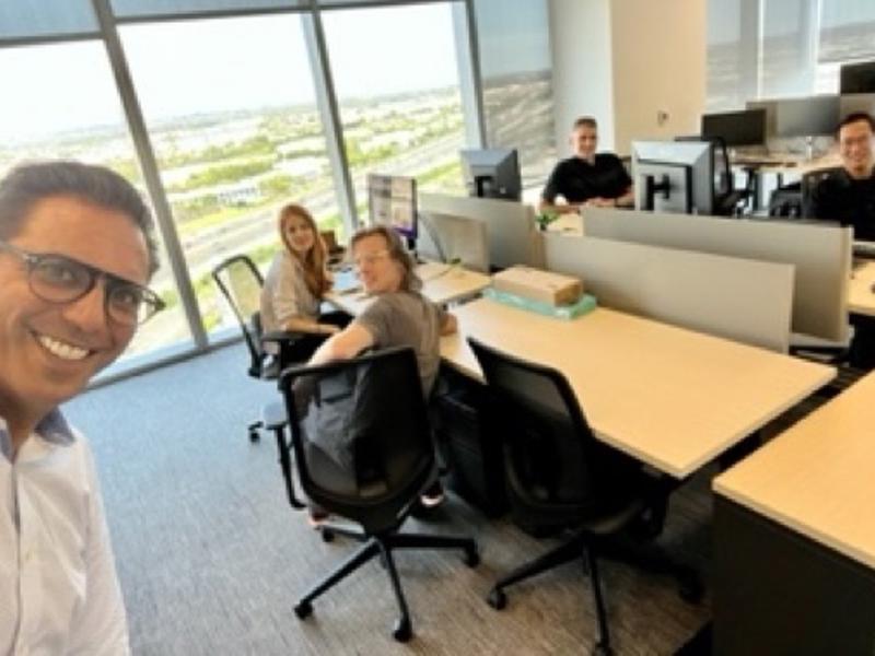 a person smiling at a group of people in an office